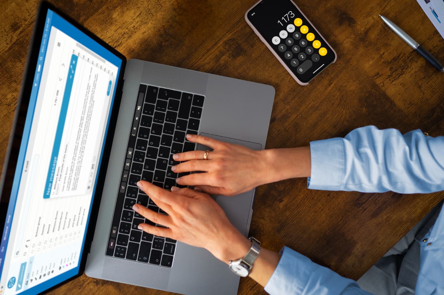 Person using a laptop and calculator app to manage payroll and HR tasks